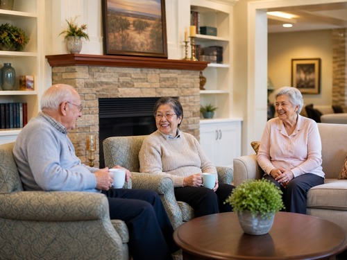 Senior living community exterior with families arriving for a visit